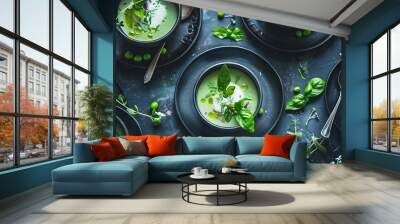   Black plates topped with bowls of soup and green garnishes Wall mural