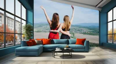 Two girls play sports on a cliff. Yoga in nature. Wall mural