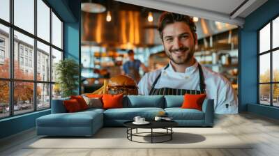 Chef holding a hamburger in the restaurant Wall mural