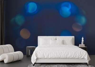 Blurred background of blue cold lights in an oval shape and dark background. Blurred jewel image. Wall mural