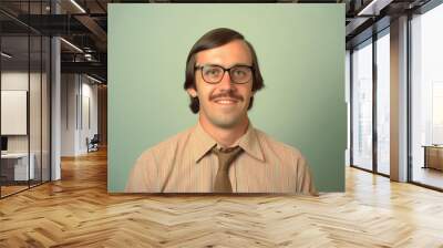 Portrait of a smiling man with glasses, mustache, and striped shirt with a tie against a light green background Wall mural