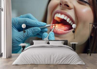 Close-up portrait of female patient with open mouth in modern dentistry clinic during medical check up in medical center. Dentist examining young woman teeth with dental tools. Dental health care. Wall mural