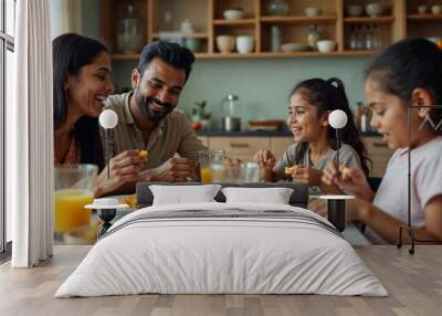 Indian young Family of four eating food at dining table at home or in restaurant. South Asian mother, father and two daughters having meal together Wall mural