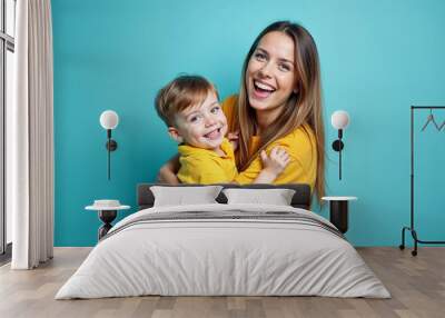 Woman in yellow clothes have fun posing with cute child baby boy 4-5 years old. Mommy little kid son isolated on blue background studio portrait. Mother's Day love family parenthood childhood concept. Wall mural