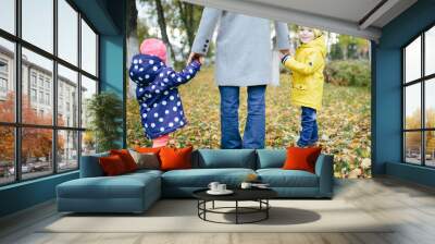 The family walks in the autumn park on a cloudy day. Wall mural