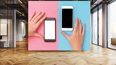 female hands hold two phones black and white. Wall mural