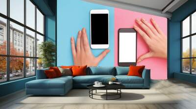 female hands hold two phones black and white. Wall mural