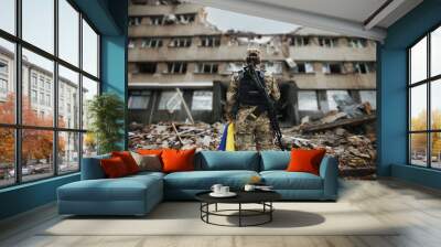 Ukrainian military woman with the Ukrainian flag in her hands on the background of an exploded house Wall mural