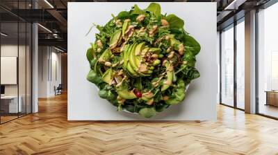 top view of a vibrant green vegan salad, artfully arranged on a white background Wall mural