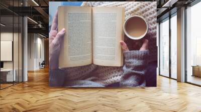 a woman is reading a book and holding coffee Wall mural