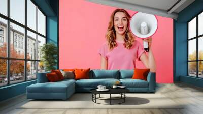 Beautiful woman screaming in megaphone on pink background Wall mural