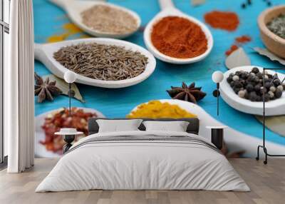 Concept of table with spices in wooden spoons on blue background, close up, selective focus Wall mural