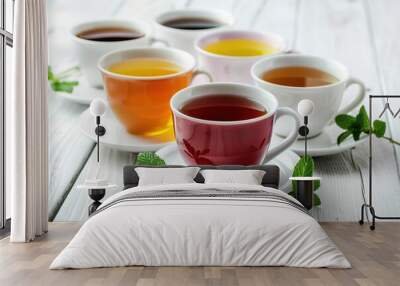 Different cups of aromatic tea on wooden table Wall mural