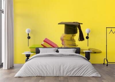 Graduated cap with coins on yellow background. Savings for education, school allowance or financial literacy concept Wall mural