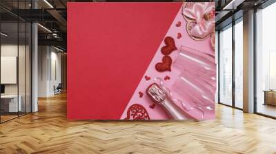 Layout two red hearts, glasses, champagne, flowers on a pink-red background with copy space valentines day date or party concept Wall mural