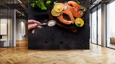 Raw fresh salmon on a wooden cutting board with red pepper, lemon, sea salt, black pepper, green salad food photo. Omega 3 vitamin fish oil copy pace banner top view low key. Wall mural