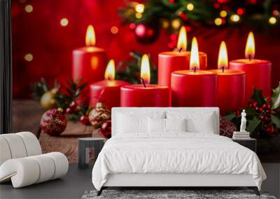 Christmas candles with a christmas decoration on it. A bunch of candles that are on a table. Bunch of red candles burning on wooden table with traditional christmas pine decoration on wood textured Wall mural