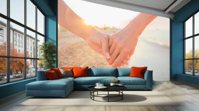 close up of two female holding hands against sunset - two girls walking on the beach hand by hand -  Wall mural