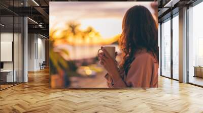 Lonely romantic girl drinking coffee looking at sunset. Wall mural