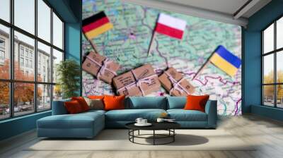 The flags of Germany, Poland and Ukraine lie on a world map next to delivered parcels. Economy, aid, trade Wall mural