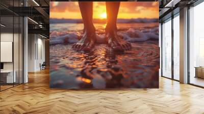 Close up man's feet standing on a beach, small waves, sunset, red sunlight. Wall mural