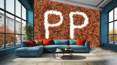 background with texture made of of brown flax seeds with a white letter of vitamin PP Wall mural