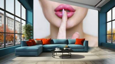 Woman with pink lipstick and finger showing hush silence sign, gesture and beauty concept, gray background. Wall mural