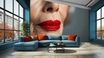 Portrait of a beautiful older woman with wrinkled face and bright make-up red lips on a light background Wall mural