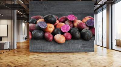 Fresh colorful potatoes on the wooden brown table Wall mural