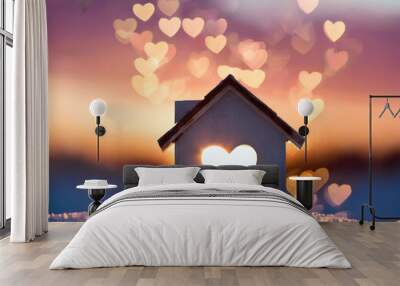 Miniature house with heart shape window on sunset background. Sweet home concept. Family warmth, love and protection Wall mural