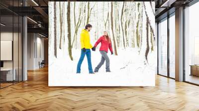 Beautiful couple walking in the winter forest Wall mural