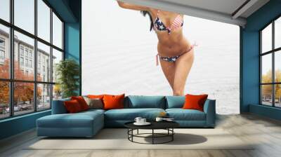 Beautiful young girl with fitness body on the beach in a swimsuit posing Wall mural