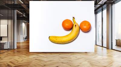 One banana with two oranges on white background. Penis shape concept Wall mural