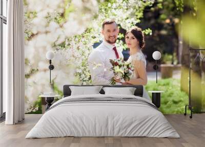 bride and groom in a blooming spring garden Wall mural