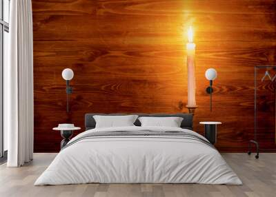 burning old candle with vintage brass candlestick on wooden back Wall mural