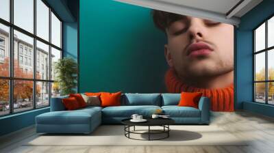 close-up of young man in sweater pucker lips,close eyes and waiting Wall mural