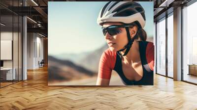 One athletic young woman cycling outside, Sporty fit female wearing helmet and glasses while riding a bike on a road along the mountain for exercise, Endurance and cardio during a workout and training Wall mural