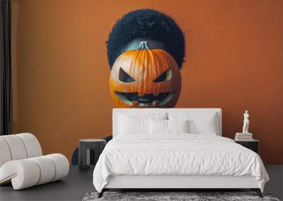 person with pumpkin for head stands against orange background, creating striking Halloween themed image. contrast between pumpkin and dark attire adds unique and eerie vibe Wall mural