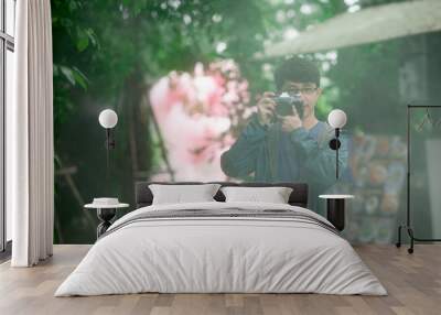 Asian male photographer holding old vintage film camera with light mist in the morning Wall mural