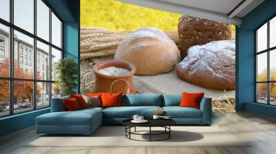 Three loafs of bread, wheat ears and clay pot Wall mural