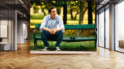 handsome adult man sitting on bench Wall mural