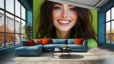 beautiful green eyed brunette woman wearing knited vibrant lime green sweather is smiling on camera, isolated on pastel solid smooth green background Wall mural