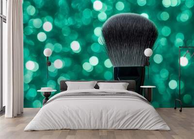 Close-up of a makeup brush against a emerald green, glittery background Wall mural