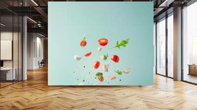 cooking ingredients floating in the air over a frying pan on a pastel background Wall mural