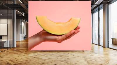 hand holding melon slice on pink background, pastel color style, close up shot, minimalist style Wall mural