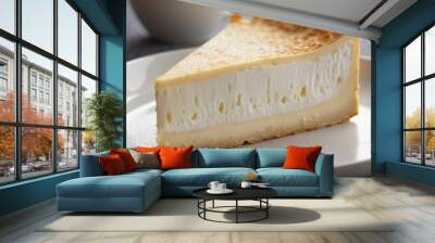 A close-up of a slice of creamy Brie cheese highlighting its velvety texture and white rind, perfect for spreading on crackers or enjoying with fruits and wine on a gourmet cheese platter Wall mural