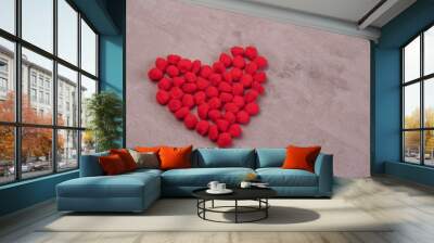 a heart made of fluffy balls on a red background .the concept of valentine's day and all lovers Wall mural