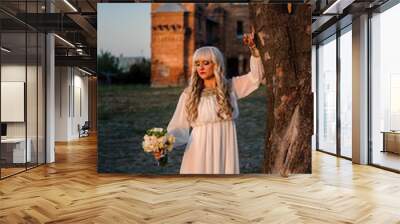 blonde girl in a white dress on nature near architectural monuments in the open air Wall mural