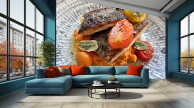 Two seabass fillets with tomatoes on a bed of red lentils puree on a rustic ceramic plate. Healthy eating healthy lifestyle concept. Mediterranean diet.  Wall mural