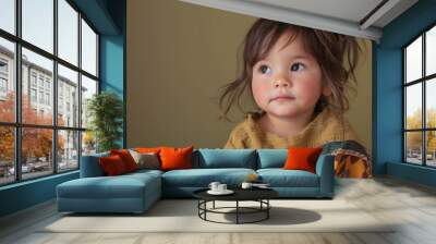 A cute toddler wearing traditional ethnic clothing, looking away with a curious expression Wall mural